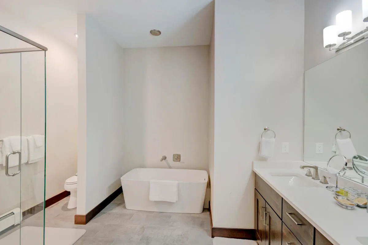 A modern bathroom featuring a freestanding bathtub, a glass shower enclosure, and a double sink vanity. The space exudes spa-like tranquility, perfect for relaxation and self-care routines.