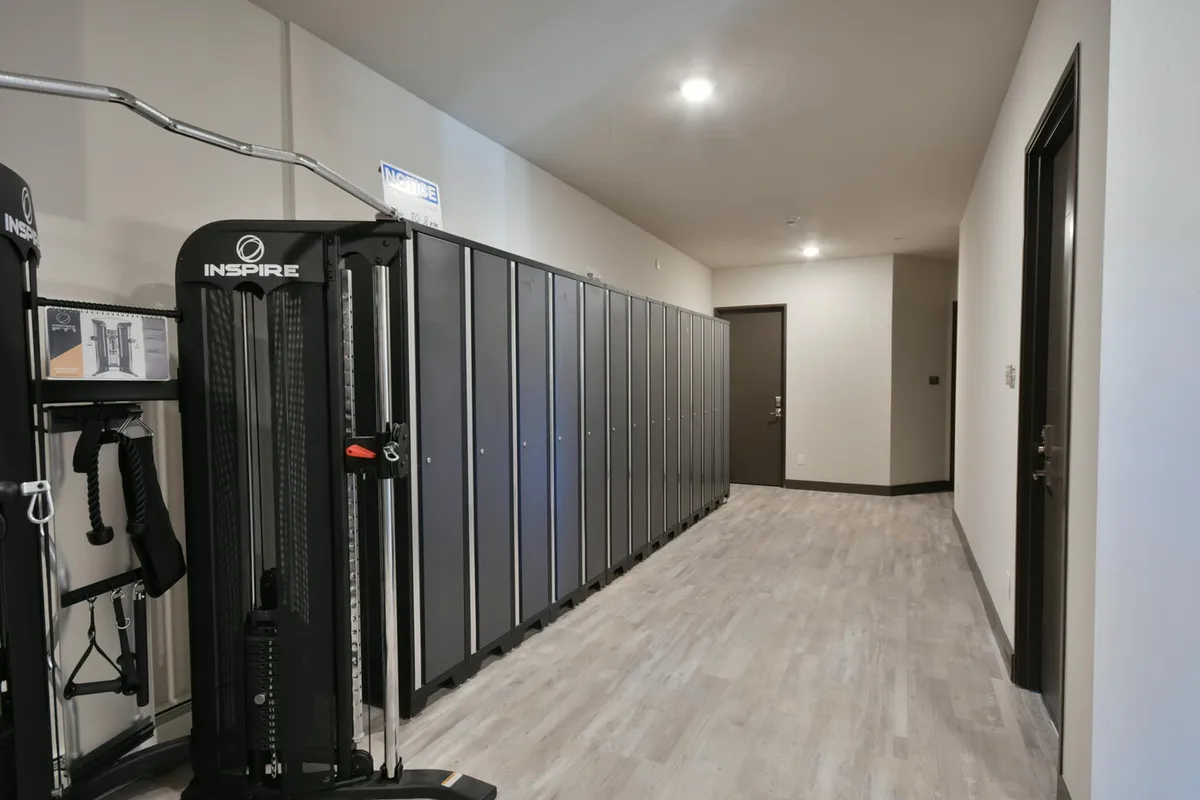 This interior shot shows exercise equipment, lockers, and a doorway, emphasizing practical storage and the transition between activity and relaxation. The presence of lockers hints at secure storage for gear, aligning with the ski lockers and convenience features described in the section.